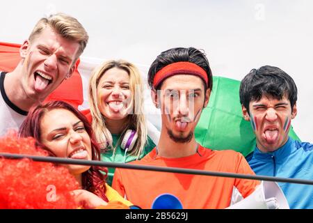 Heureux supporters de sport ayant du plaisir pendant le match de football mondial - jeunes fans au stade avant le match de football - amitié, jeunesse et concept de sport - Main Banque D'Images