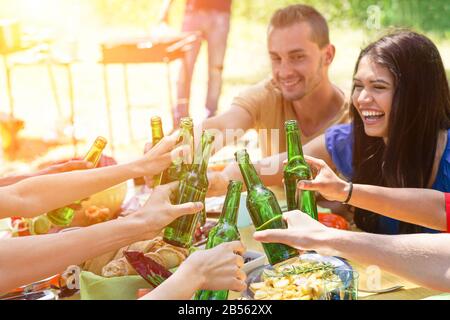 Groupe d'étudiants multiraciaux ayant barbecue le jour ensoleillé - jeunes gens applaudissante avec bière en été sur barbecue - concept sur bon et positif m Banque D'Images