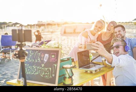 Heureux les gens qui prennent selfie et de la vidéo de la fête de plage au coucher du soleil - l'homme vlogger utilisant la caméra de téléphone mobile pour filmer la diffusion en direct - New technolo Banque D'Images