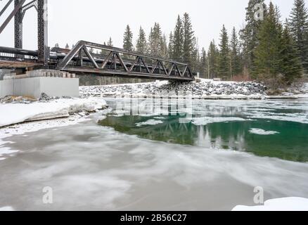 Journée enneigée au passage piétonnier du pont moteur au-dessus de la rivière Bow à Canmore, Alberta, Canada Banque D'Images