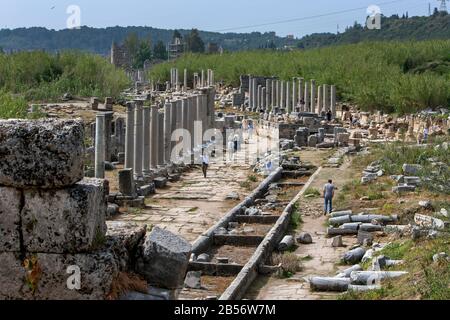 Vue du nord de Nympheum (fontaine d'eau) en regardant la rue à colonnades à Perge en Turquie avec de nombreuses colonnes de pierre toujours debout. Banque D'Images