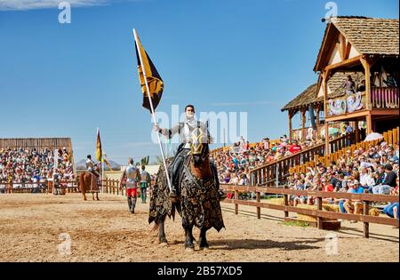 Gold Canyon, Arizona, États-Unis - 29 février 2020: Un participant de tournoi joutant un cheval en costume tenant un drapeau au Renaissance Festival Banque D'Images