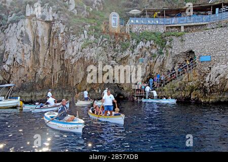 Touristes en petits bateaux attendant d'entrer dans la célèbre Grotte bleue sur l'île de Capri. Les conducteurs tirent les bateaux par une petite ouverture. Banque D'Images