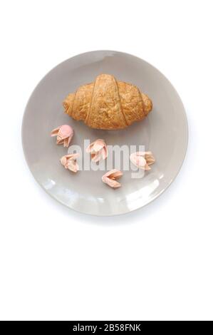 Croissant aux fleurs décorées avec vue sur le dessus de la plaque grise Banque D'Images