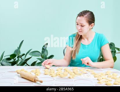 une fille dans la cuisine fait des boulettes avec du fromage cottage Banque D'Images