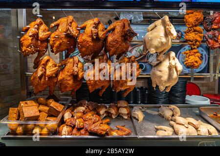 Poulets entiers rôtis accrochés à la vitrine transparente du restaurant chinois Banque D'Images