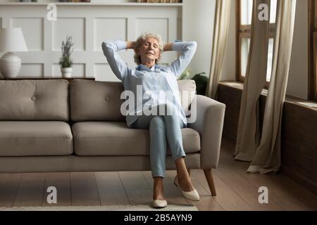 Femme mûre se détendre sur un canapé prenant la sieste à la maison Banque D'Images