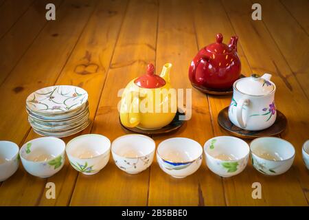 Thé blanc et rouge jaune sur la table en bois avec plat blanc et tasse dans la première rangée d'entre eux. Banque D'Images
