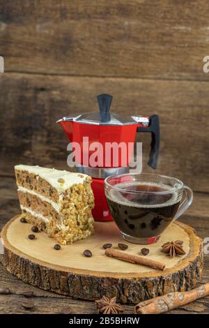 Une tasse de café chaud avec gâteau et cafetière italienne (Moka) sur table en bois. Banque D'Images