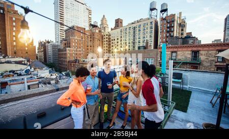 Groupe d'amis qui passent du temps ensemble sur un toit dans la ville de New york, concept de style de vie avec des gens heureux Banque D'Images