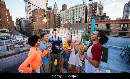 Groupe d'amis qui passent du temps ensemble sur un toit dans la ville de New york, concept de style de vie avec des gens heureux Banque D'Images