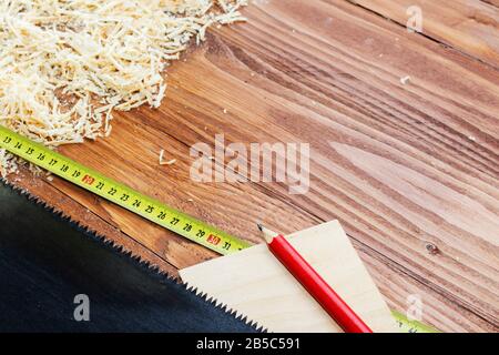 de nombreuses briques en bois pleines de sciure. Sur une table en bois rayée, concept d'outils de travail. Banque D'Images