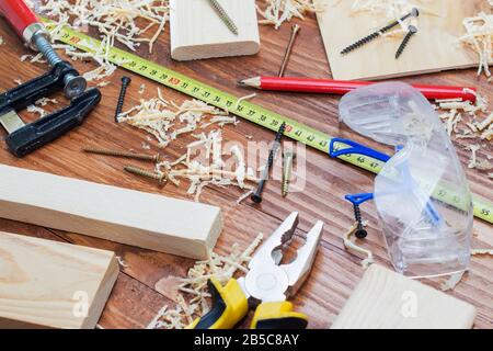 de nombreuses briques en bois pleines de sciure. Sur une table en bois rayée, concept d'outils de travail. Banque D'Images