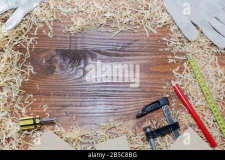 de nombreuses briques en bois pleines de sciure. Sur une table en bois rayée, concept d'outils de travail. Banque D'Images