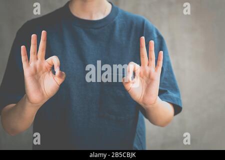 Femme debout et signe de main positif approuvant conceptuel. Banque D'Images