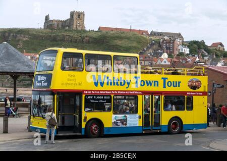 Un bus à impériale Whitby Town Tour dans le port historique de Whitby sur la côte est du Yorkshire du Nord, en Grande-Bretagne, face à la mer du Nord. Whitby, A. Banque D'Images