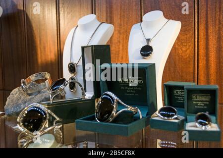 Une grande vitrine d'anneaux et de colliers noirs de jet de pierres précieuses organiques fabriqués à la main Whitby à W.Hamond, le célèbre bijoutier original Whitby Black Jet Banque D'Images