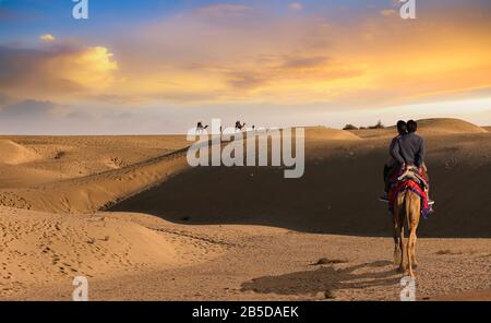 Les touristes apprécient un safari à dos de chameau au coucher du soleil au désert de Thar Jaisalmer Rajasthan, Inde Banque D'Images