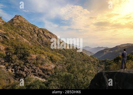 Les touristes masculins profitent d'une vue sur le lever du soleil au Mont Abu Rajasthan, en Inde, avec un paysage de montagne pittoresque Banque D'Images