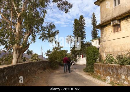 Couple prendre une promenade le long d'une route de montagne au Mont Abu Rajasthan au lever du soleil. Mount Abu est une station de montagne dans l'État du Rajasthan dans l'ouest de l'Inde Banque D'Images