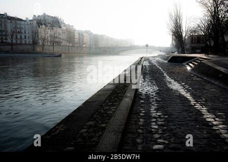 Vue brumeuse le matin sur le remblai de la Seine à Paris, France. Banque D'Images