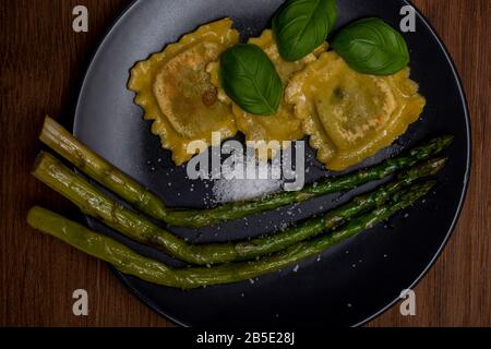 Gros plan cuisson des asperges pour le dîner dans un pot servi avec des pâtes italiennes de tortelini, pour le dîner et le déjeuner Banque D'Images