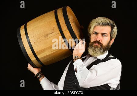 homme vigneron. homme barbu explorez le goût du vin au restaurant. Contrôle de la couleur et des sédiments du vin. Dégustation de vins. Le sommelier qualifié masculin estime la boisson alcoolisée. Le vin dans le baril. Banque D'Images