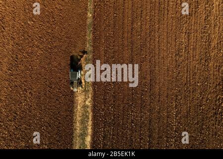 Drone aérien tiré d'un agriculteur dans l'ensemencement de tracteurs, semant des cultures agricoles sur le terrain dans les champs fertiles de Kilkis en Grèce du Nord Banque D'Images