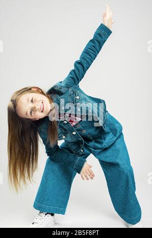 bébé en mouvement. mode enfants petite fille fait mouvement avec ses bras et ses jambes. danse de l'enfant. Photographie de studio Banque D'Images