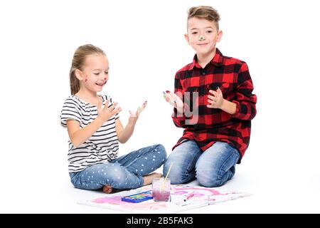 Frère et sœur s'amuser avec la peinture à l'aquarelle. Heureux enfants créatifs à la classe d'art. Concept art-thérapie sur fond blanc. Banque D'Images