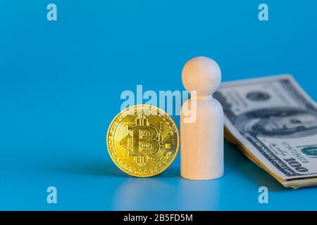 Figurine d'un homme de dollars et bitcoin sur fond bleu. Choix de concept d'affaires entre dollars et crypto-monnaie. Banque D'Images