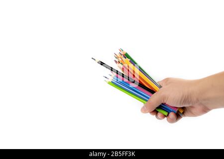 La main de l'homme asiatique tient beaucoup de crayons de couleur dans sa main, perlés par un crayon de couleur noire sur le fond blanc. Masque. Banque D'Images
