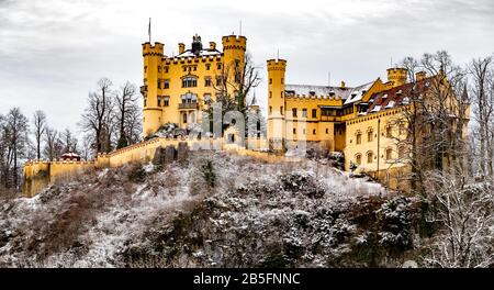 Le château royal de Hohenschwangau à Schwangau, Bavière, Allemagne (Deutschland). Le célèbre panneau de la place bavaroise le jour de l'hiver, ciel nuageux, Revival gothique Banque D'Images