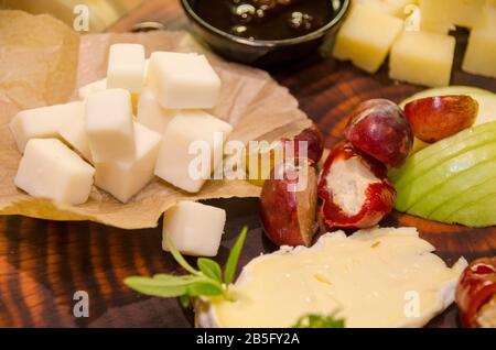 Une table de buffet avec des aliments pour les doigts. Cubes de fromage et poivrons de cerise remplis de fromage à la crème Banque D'Images