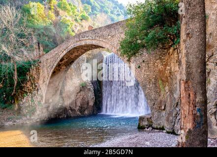 La cascade artificielle et le pont médiéval en pierre de Palaiokarya, à Trikala, Thessalonique, Grèce. Banque D'Images