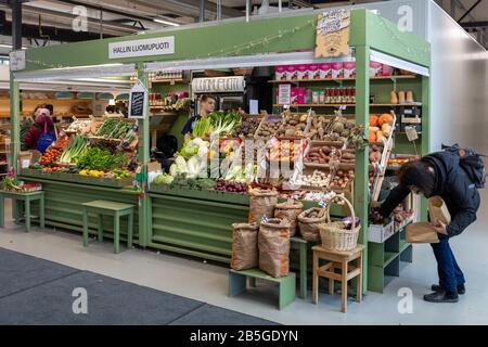 Un vendeur de légumes biologiques stalle dans une salle temporaire de marché intérieur du district d'Hakaniemi à Helsinki, en Finlande Banque D'Images