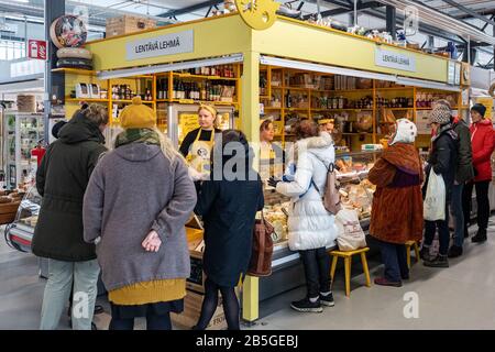 Les clients devant Lentävä Lehmä, vendeur de fromage jaune, stallent dans la salle temporaire de marché intérieure d'Hakaniemi à Helsinki, en Finlande Banque D'Images