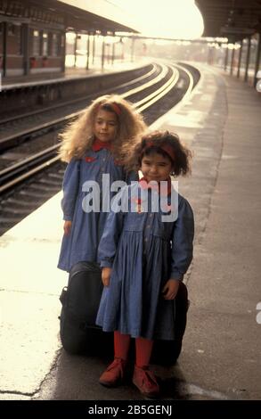 deux petites sœurs sur la plate-forme de la gare attendant le train Banque D'Images