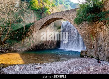 La cascade artificielle et le pont médiéval en pierre de Palaiokarya, à Trikala, Thessalonique, Grèce. Banque D'Images