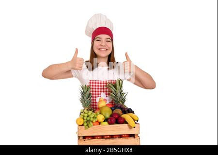 la femelle cuisinez avec des fruits et des pouces vers le haut Banque D'Images