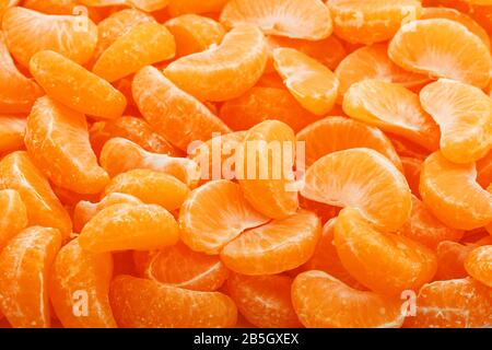 Beaucoup de tranches de tangerines juteux comme texture d'arrière-plan. Fruits utiles sur tout l'écran. Banque D'Images