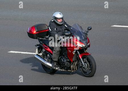 Motocyclette et pilote Red Honda CBF ; circulation automobile, transport à deux roues, véhicules modernes, motocyclettes, véhicule, routes, motocyclettes motards motards à bord de l'autoroute   Chorley, Royaume-Uni Banque D'Images