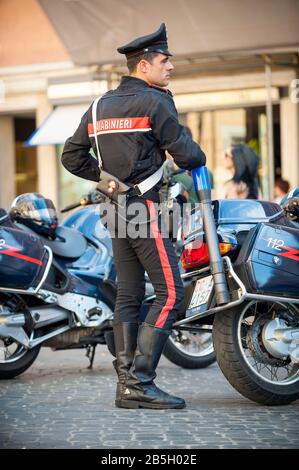 Rome - 12 MAI 2012: Le policier italien se tient en uniforme en s'inclinant contre sa moto à la Piazza di Spagna. Banque D'Images