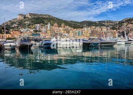 Monaco Principauté paysage urbain, yachts dans le port et la ville avec montagnes en arrière-plan. Banque D'Images