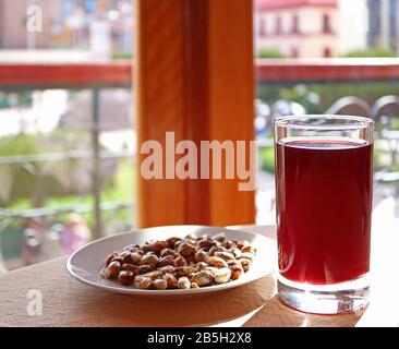 Chicha Morada, la boisson traditionnelle andine à base de maïs servie avec des grains de maïs grillés Cancha Banque D'Images