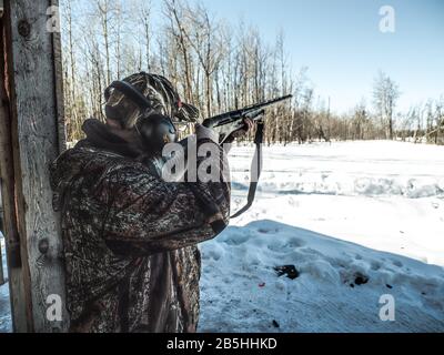 Tir de pigeons d'argile avec fusil de chasse pendant l'hiver Banque D'Images