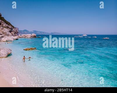 Sardaigne Côte Orosei Italie, hommes et femmes, jeune couple adulte en vacances à l'île de Sardaigne lors d'une excursion en bateau à toutes les plages de galets blancs Banque D'Images