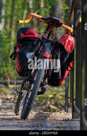 Helsinki, Finlande – 27 avril 2019 : vélo d'aventure avec vélo de montagne et capacités de vélo de tourisme et valises rouges attachées au vélo sur le pont. Banque D'Images