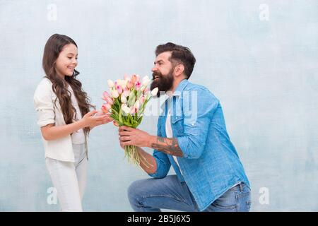 C'est pour vous une petite princesse. Journée familiale. Passer du temps ensemble. Fille prendre des tulipes. Heureux père a reçu don le jour des pères. 8 mars. Happy Women Day. Papa donner des fleurs à une petite fille en vacances Banque D'Images