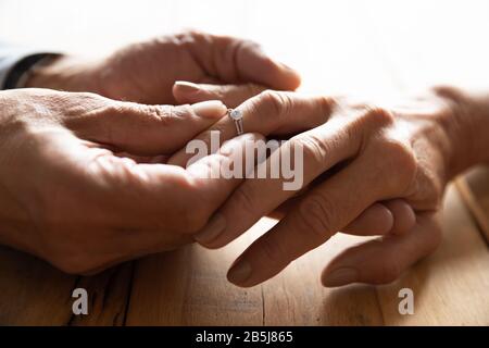 Les vieux couple échangent des anneaux de mariage s'engagent Banque D'Images